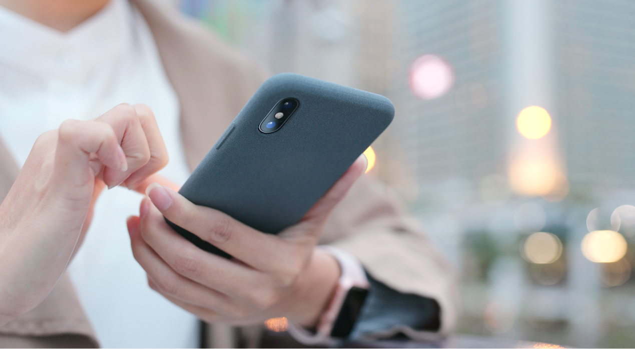 Akıllı telefon kullanan kişi, cep telefonu sigortasının günlük kullanım risklerine karşı sağladığı korumayı temsil ediyor.